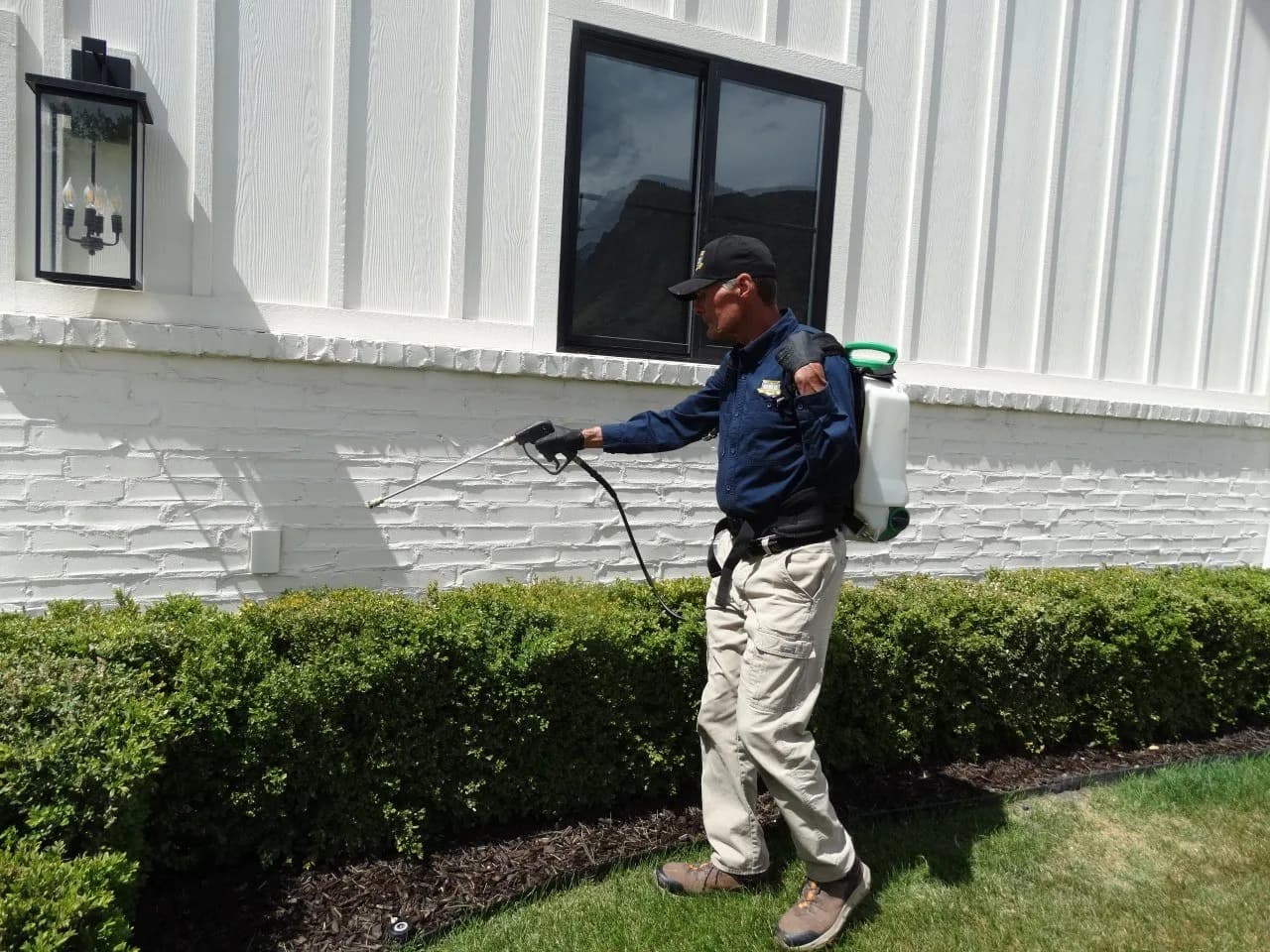 Reynolds Pest Control technician treating a Utah County home near Santaquin