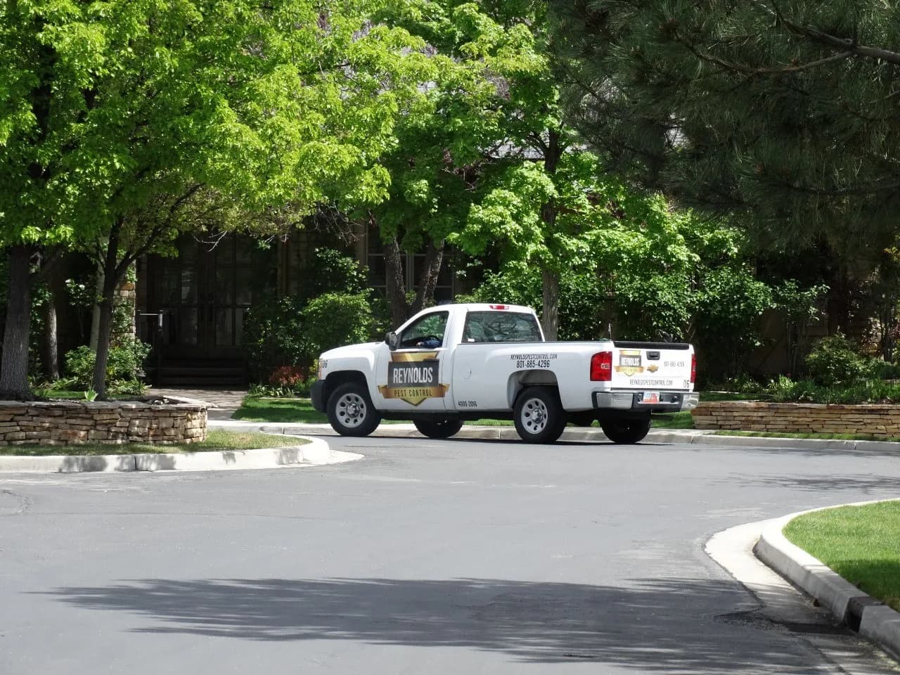 Reynolds Pest Control vehicle parked at a residential job site